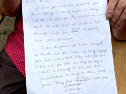 Mother holding the letter she wrote to her daughter that was printed onto the blanket